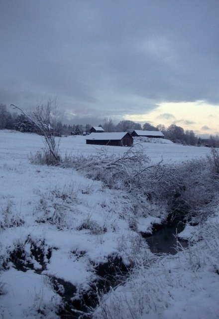 a snow covered field with some creek flowing