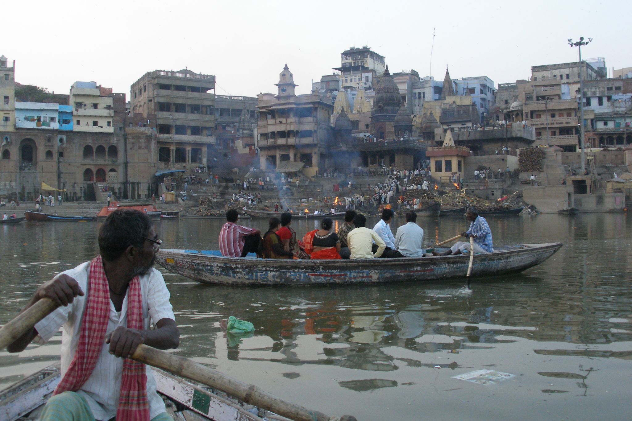 several people sit in a small boat floating through a body of water