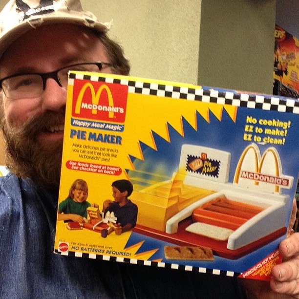 a man is holding up a mcdonalds toy