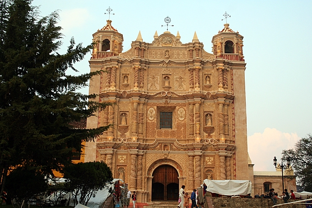 an old church with ornate architecture next to a tree