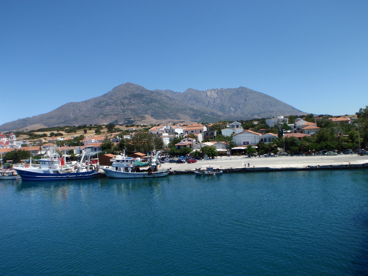 two boats tied to the shore in a harbor