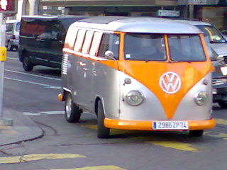 an old orange and grey van drives down the street
