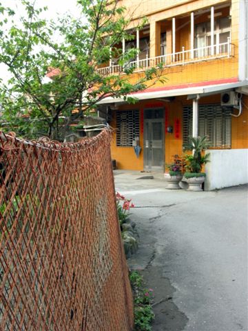 an orange building behind a wire fence