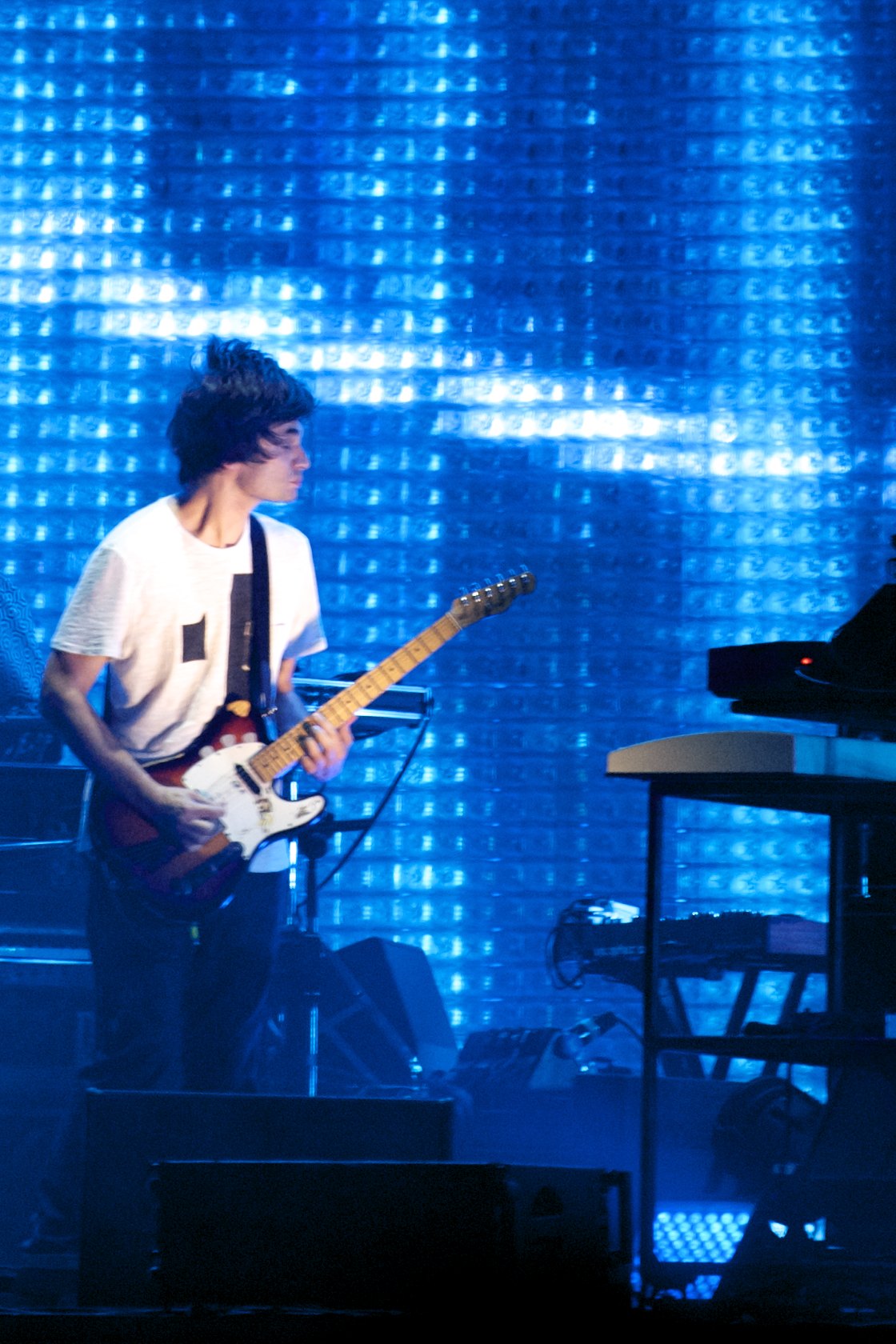 two young men performing on stage with keyboard and piano