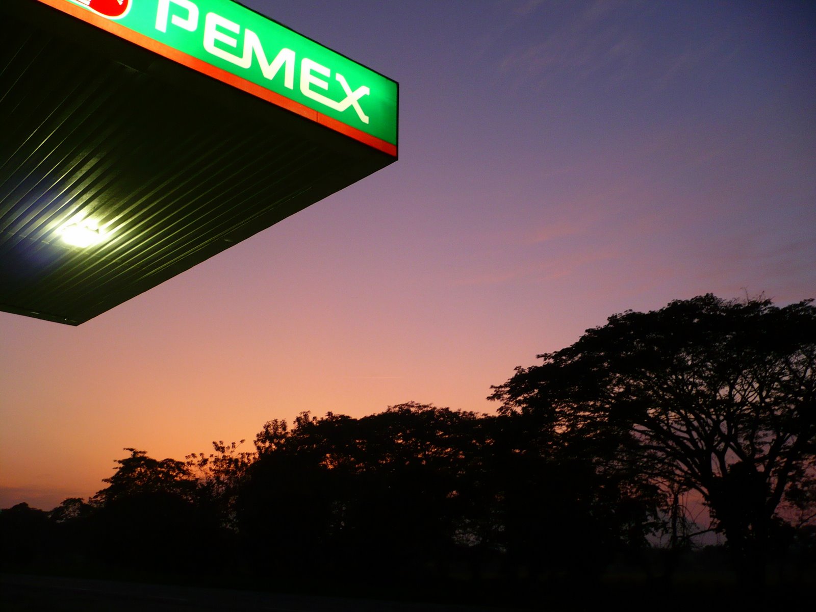 a gas station at sunset with the twilight sky behind it
