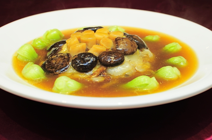 a bowl of vegetable soup with dumpling in the middle