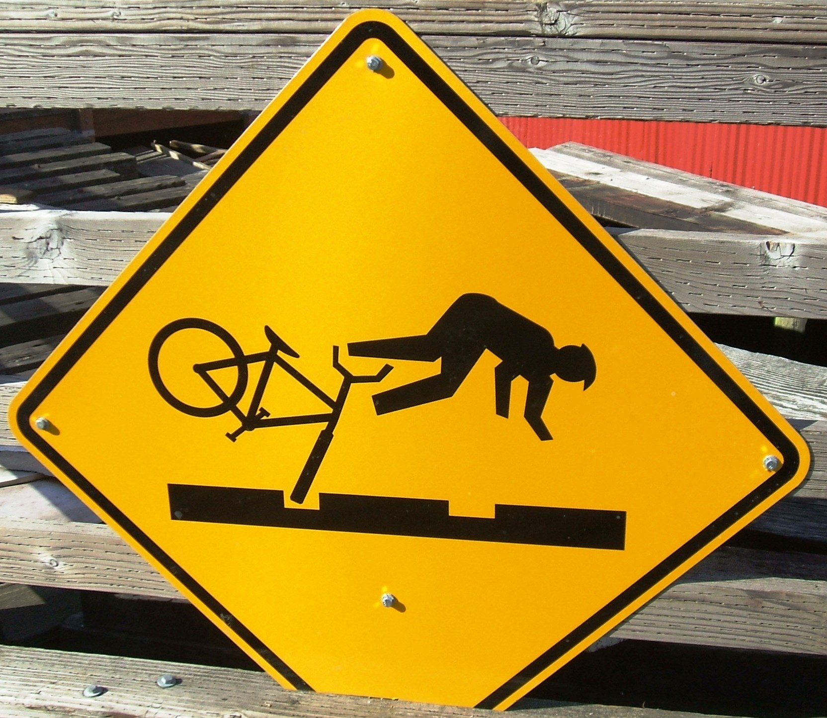 a caution sign with a person hing a bike