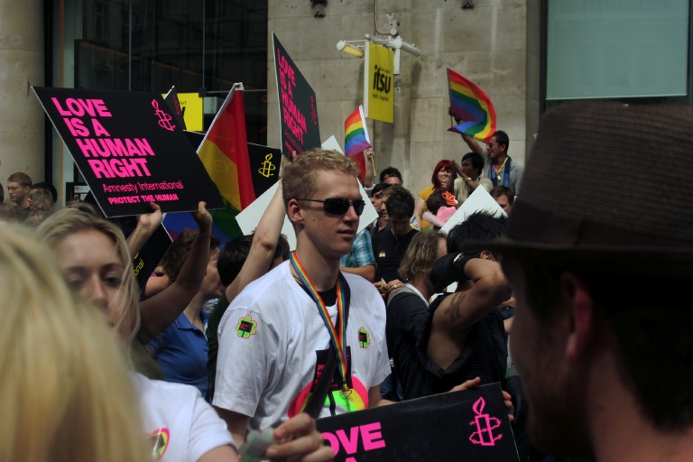 a group of people are holding signs with one man wearing shades