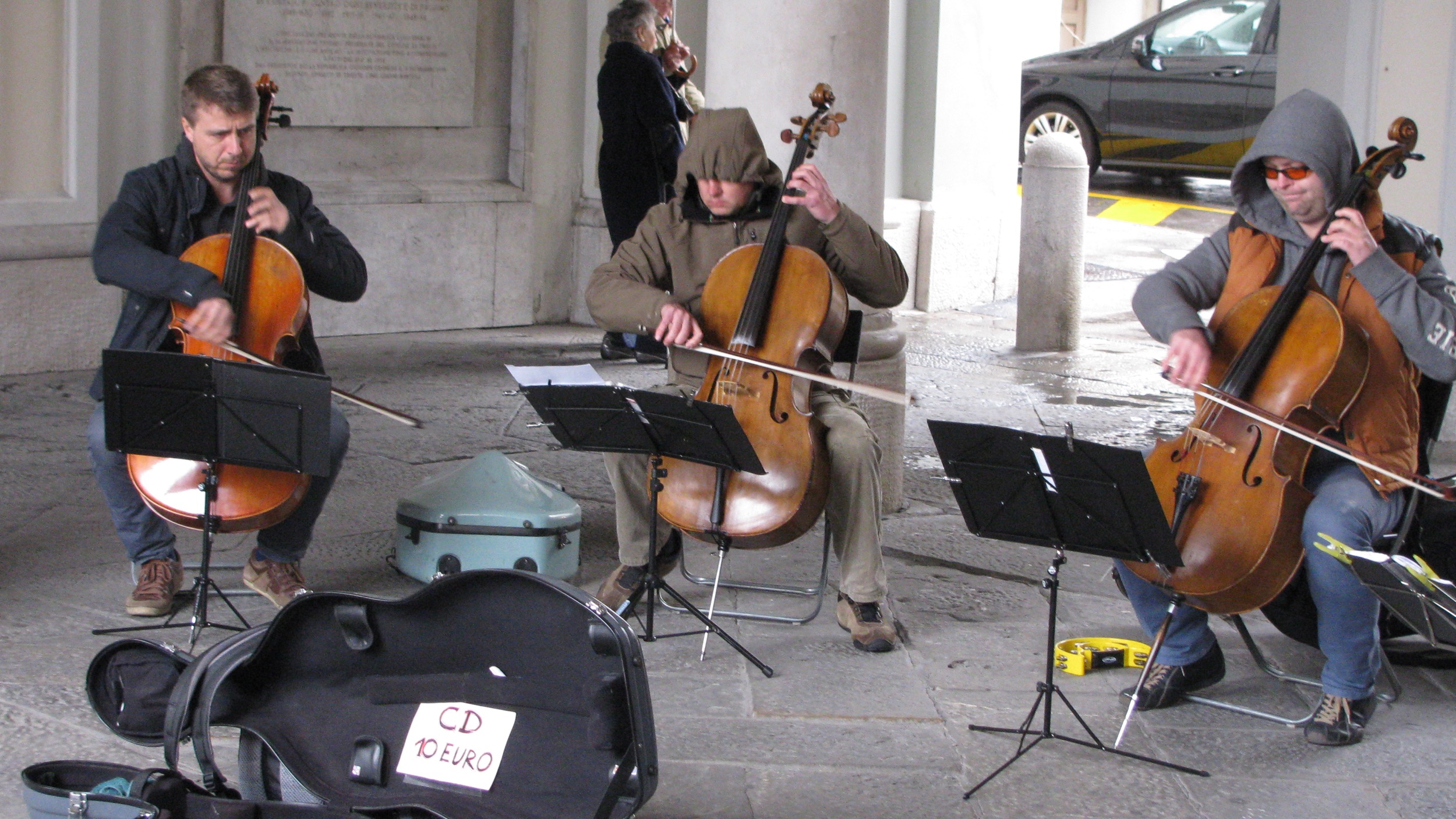 some men playing music and saxophone on a city sidewalk