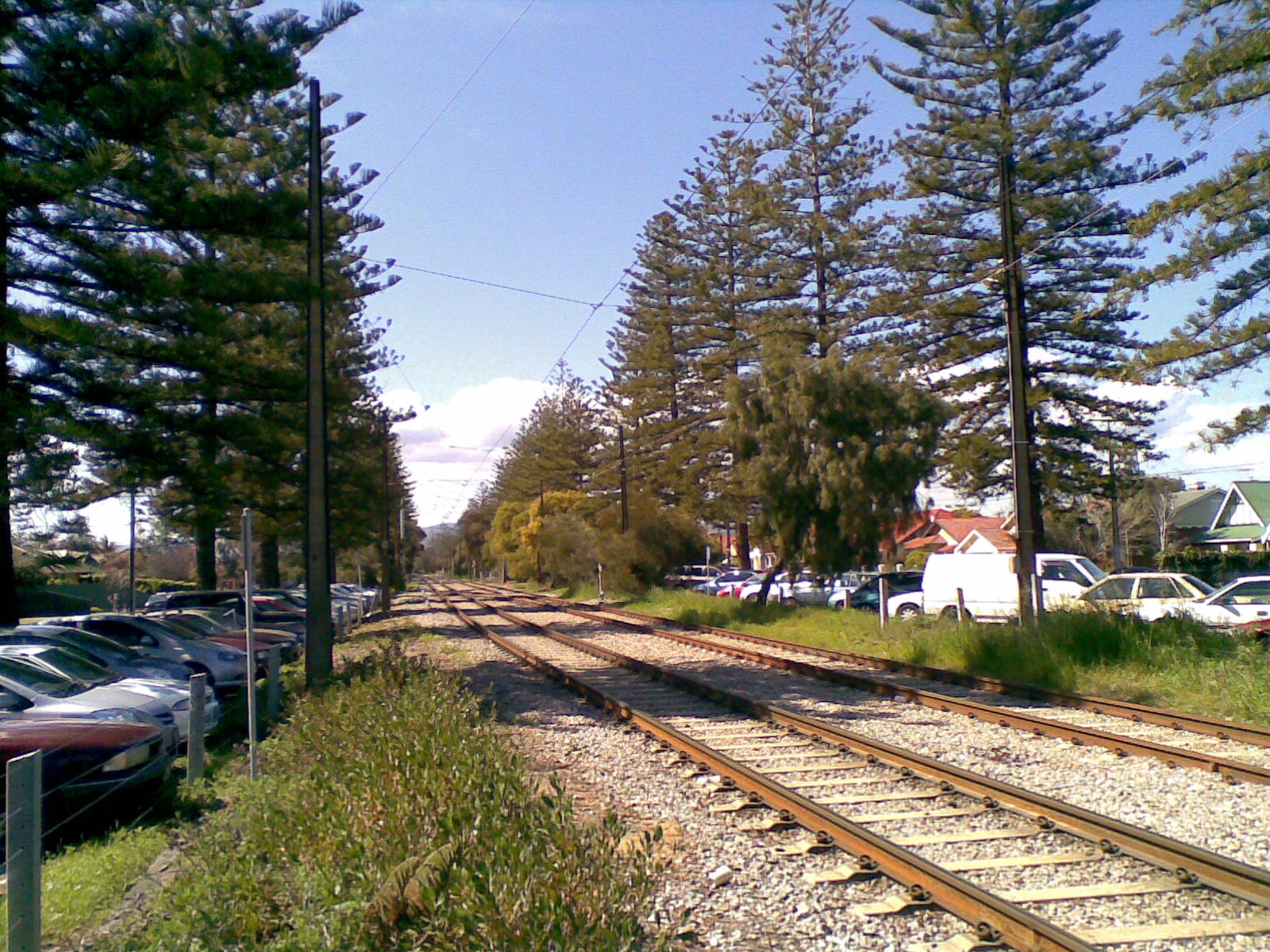 view of a train track near several parked cars