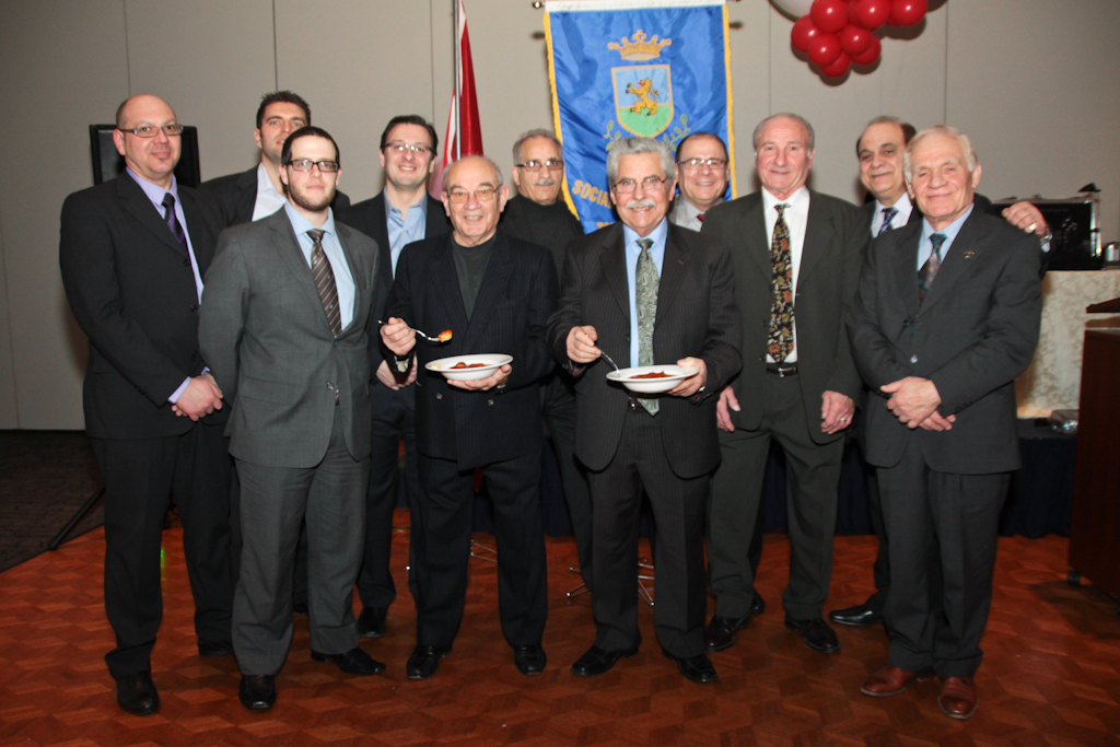 a group of men holding dishes posing for a po