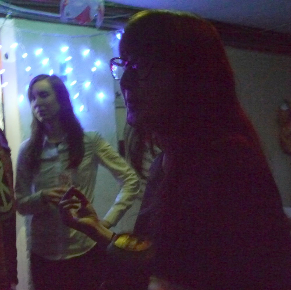 two woman in front of an indoor string light