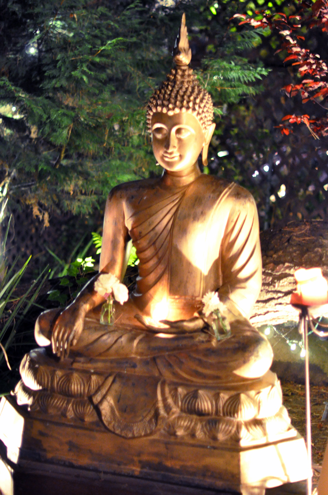 a person taking a picture of a buddha statue