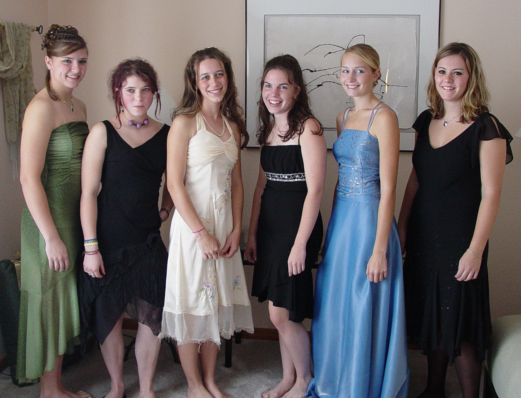 a group of women in black dresses pose for the camera