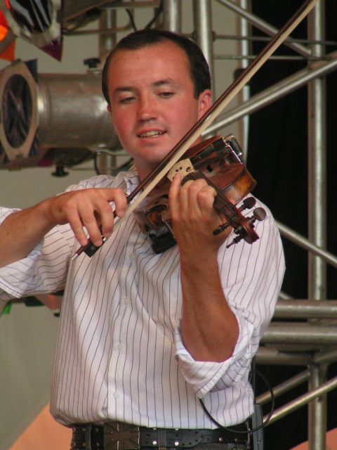 a man plays the violin in front of a crowd