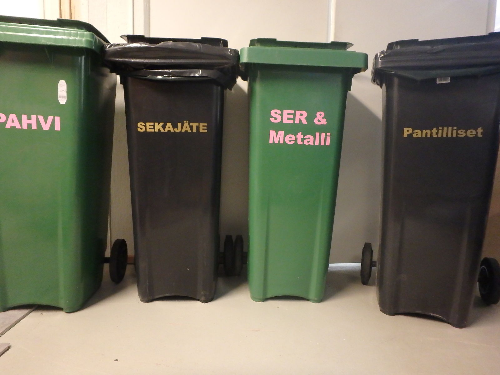 three trash cans sitting in a row with one saying seikaja & metali