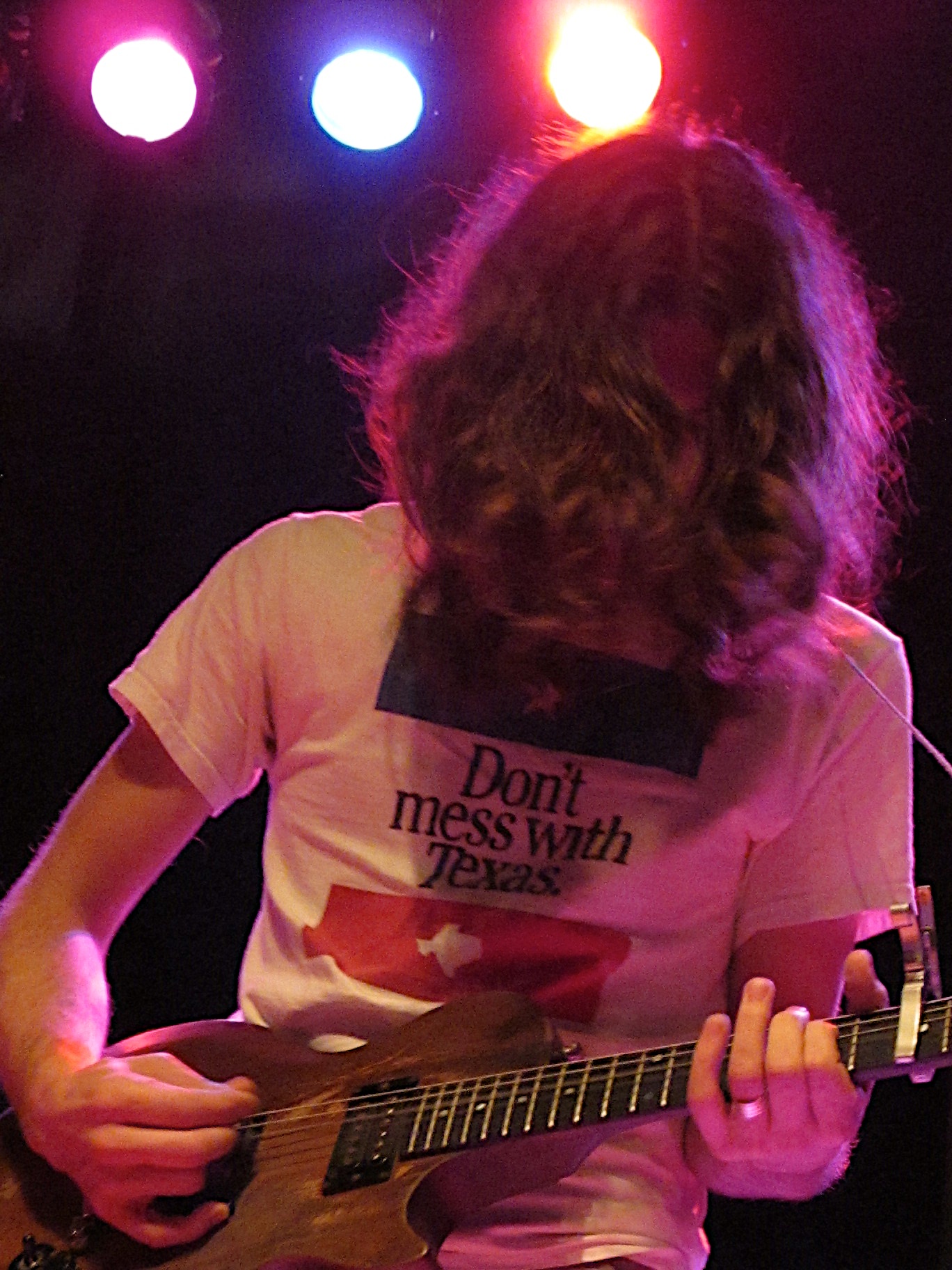 a young man plays a guitar at the end of a concert