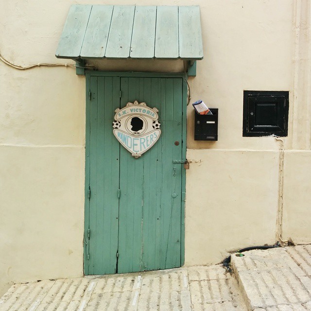 a green door and two white steps on the side of a building