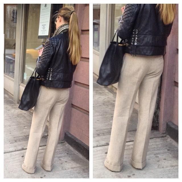 the image shows a woman in the street wearing slacks