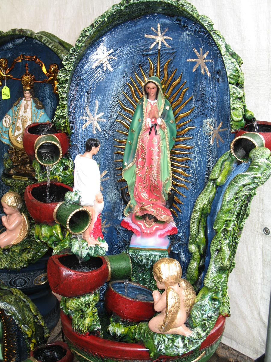 a table filled with pots and statues with a painting on it