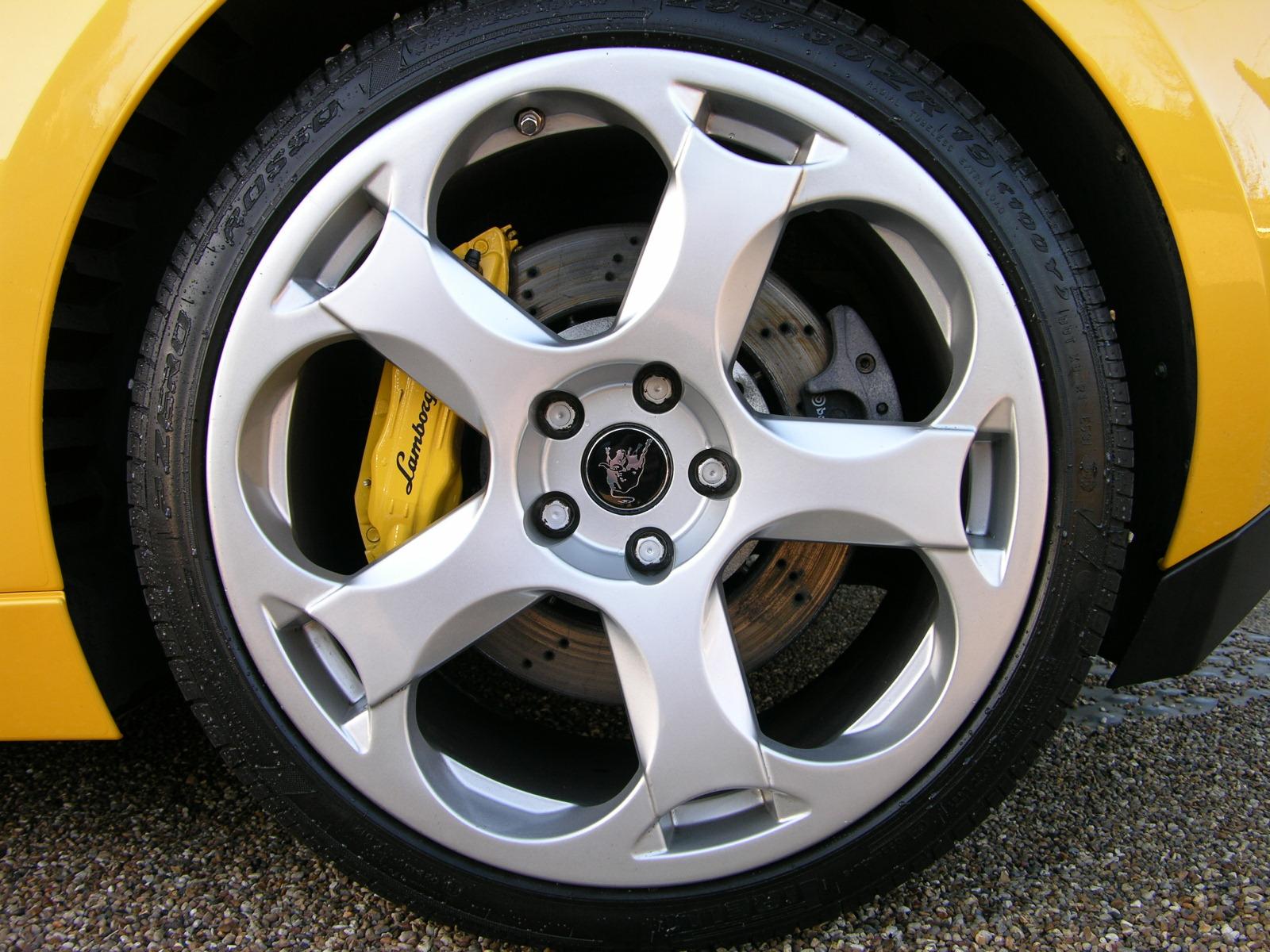 the wheels of the yellow car on the asphalt