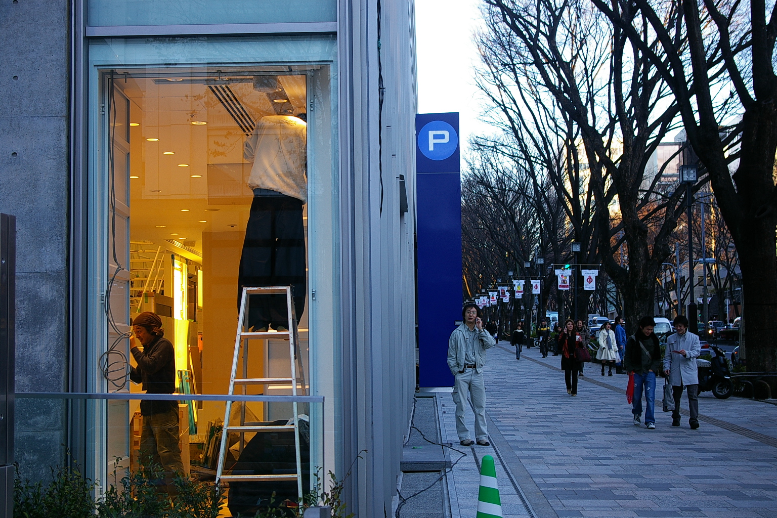 people walking past a shop called pj on a city street