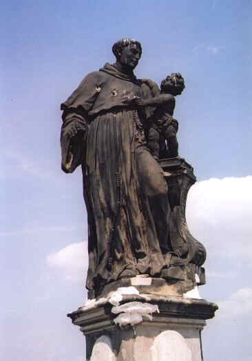 a statue stands in the foreground and appears to be holding a baby
