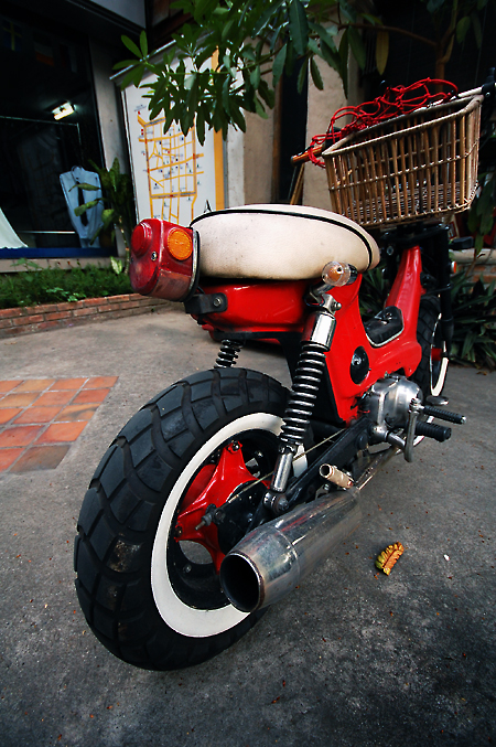 a red motor bike parked on top of a sidewalk