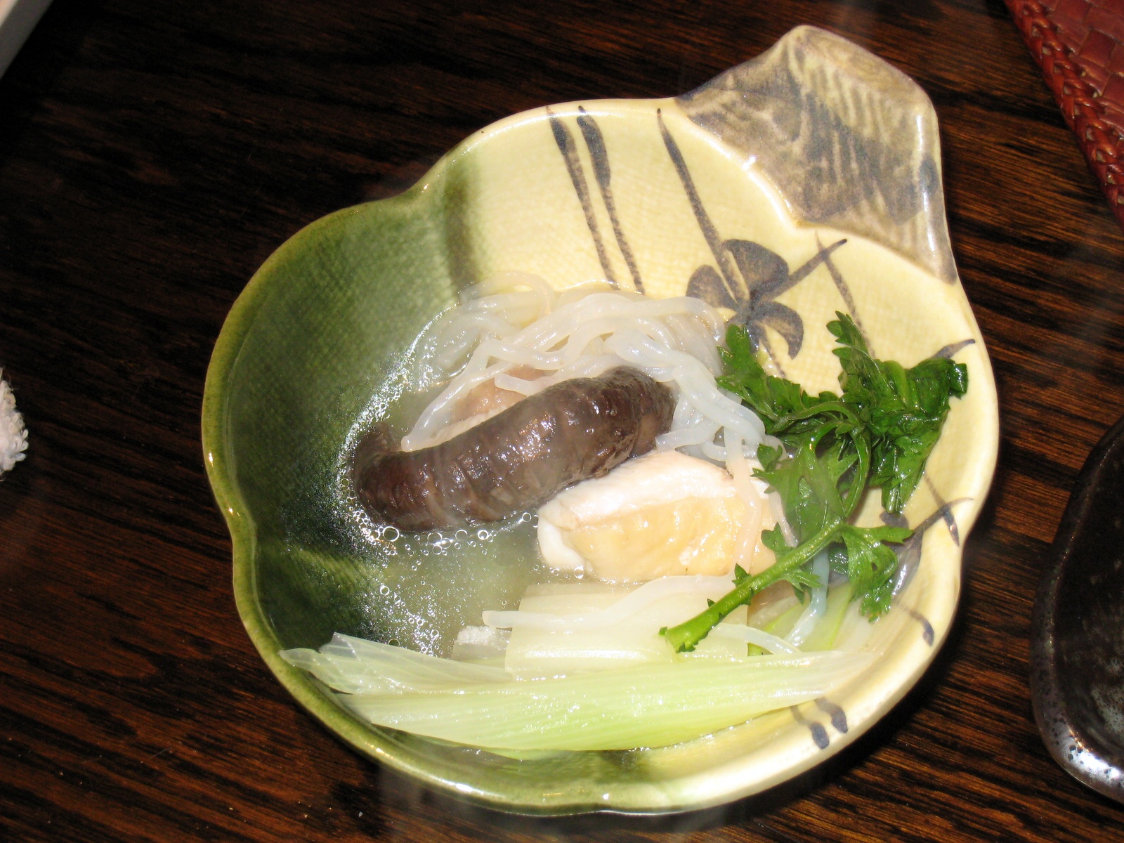 a plate with meat, veggies, and herbs in water