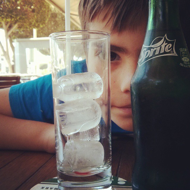 a little boy is looking at a bottle of beer