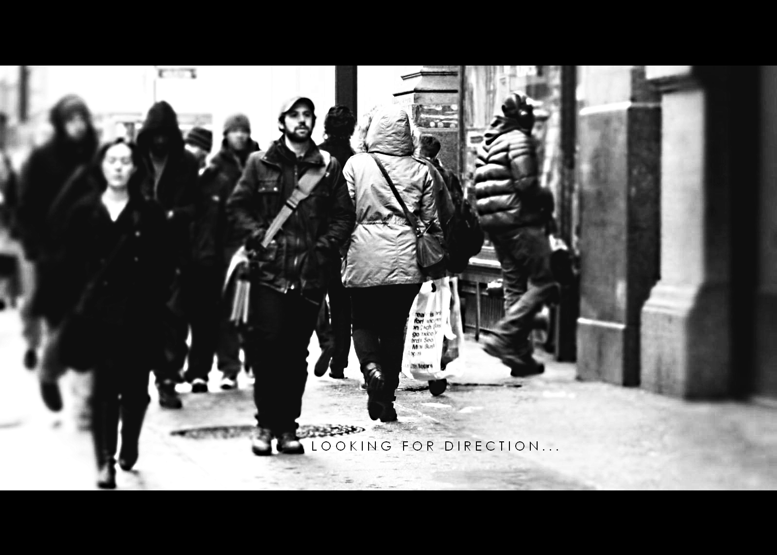 black and white pograph with some people walking on a city street