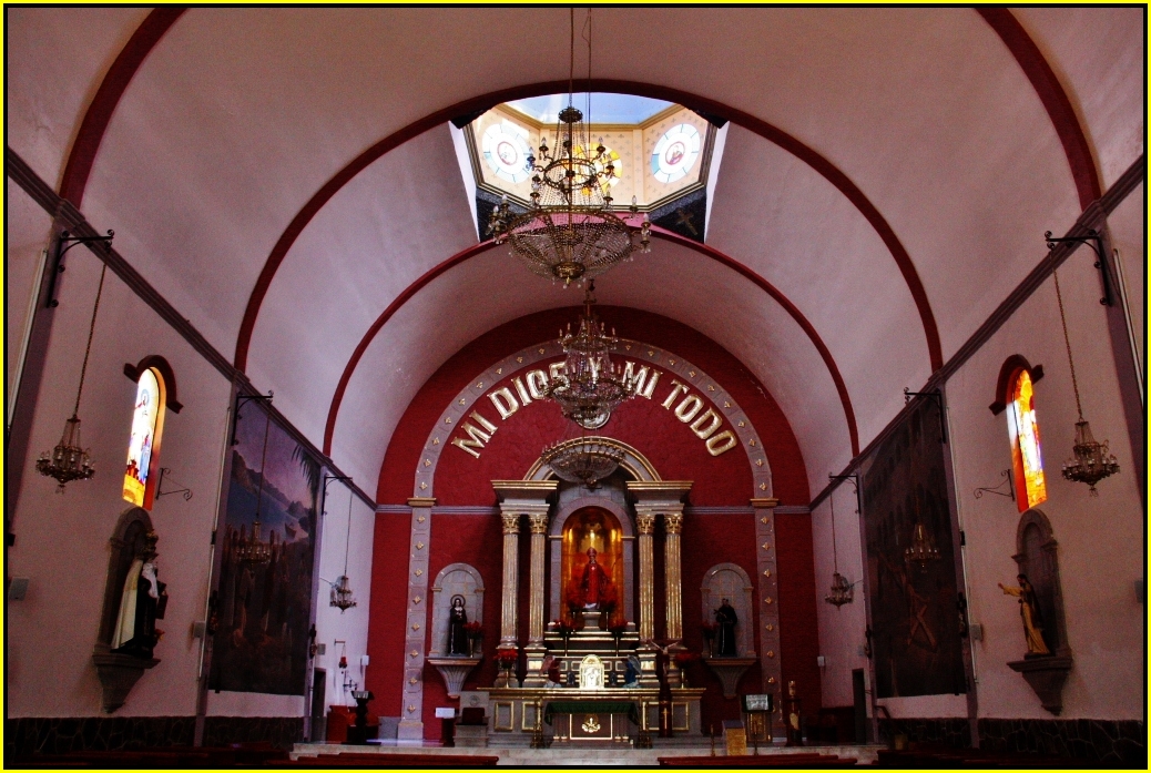 a church with a very tall alter, clock and chandelier