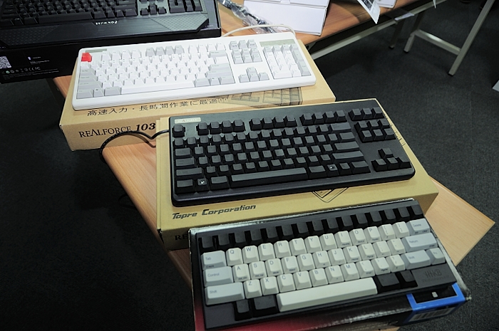 three black and white keyboards sit on an assortment of books