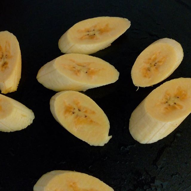 the sliced bananas are being cooked in the pan