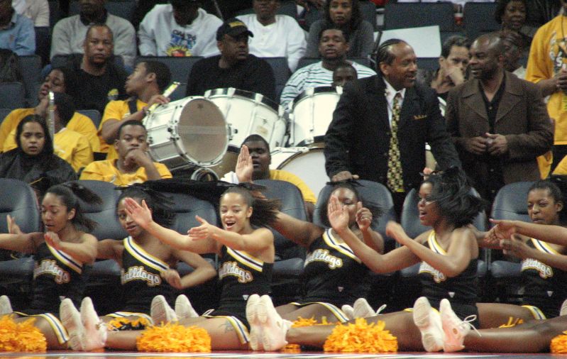 a group of cheerleaders clapping on the sidelines