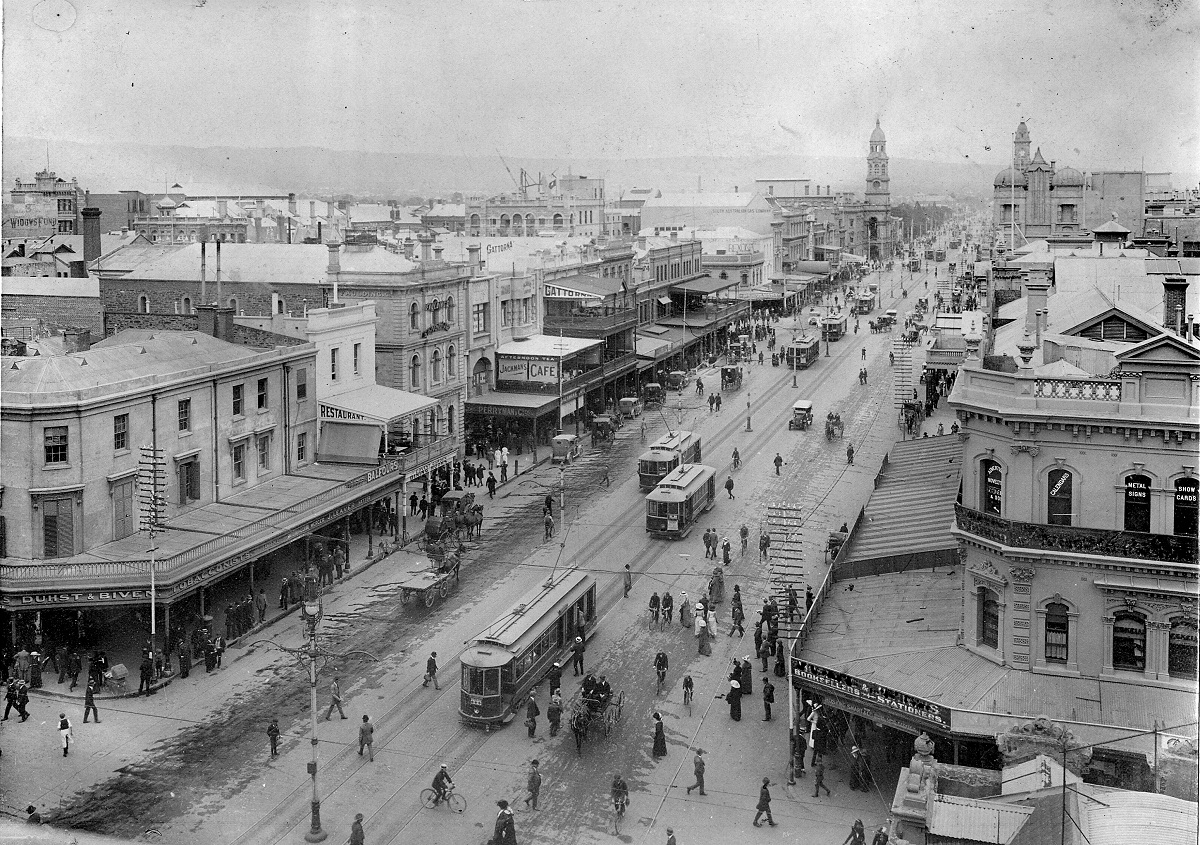 a large city has a number of old buildings and people in the streets