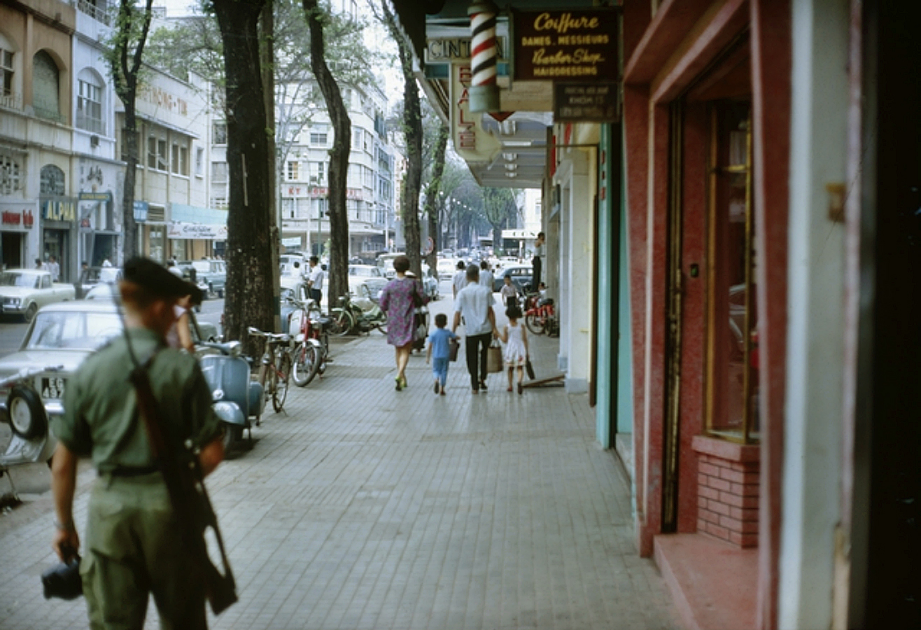 people walking in a small city next to tall buildings