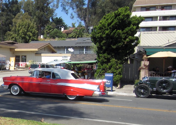 the old cars are traveling down the street