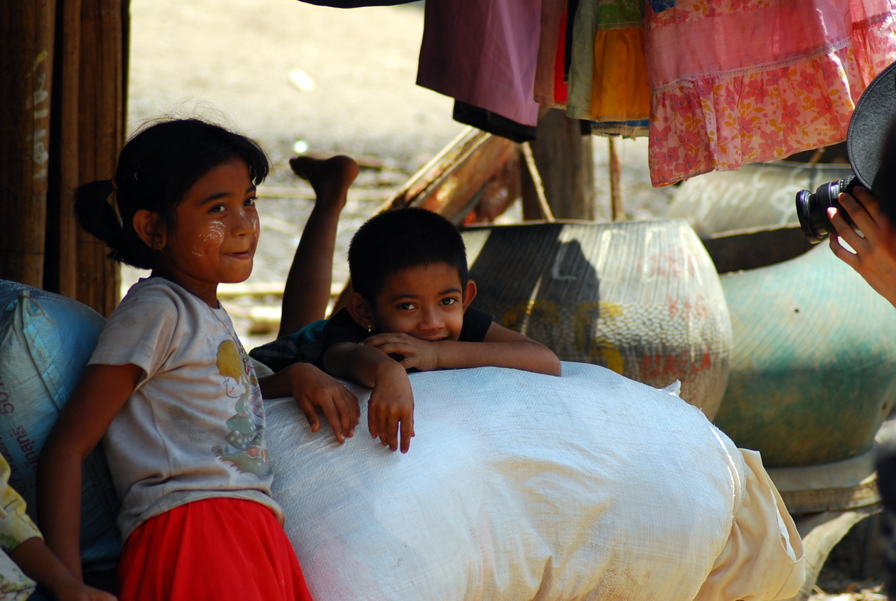 three s are sitting on a pillow in an outdoor market