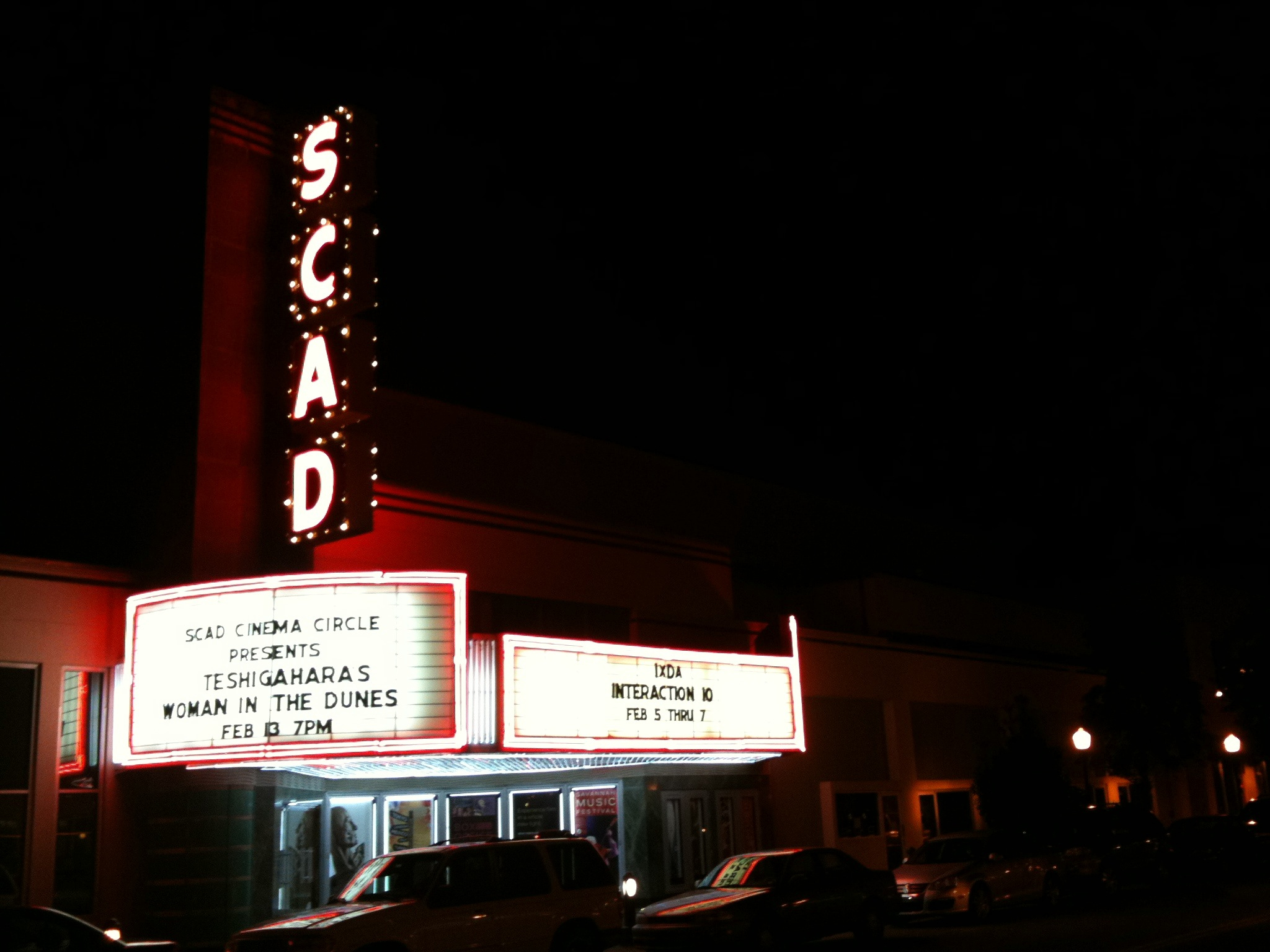 a marquee lit up in the dark on the side of a building