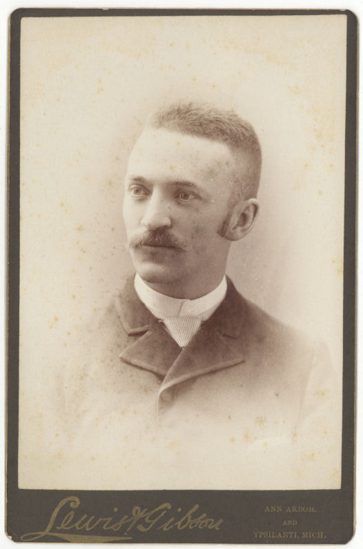 a man with a moustache is posing for the camera