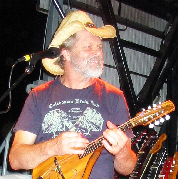 a man wearing a hat while playing a guitar