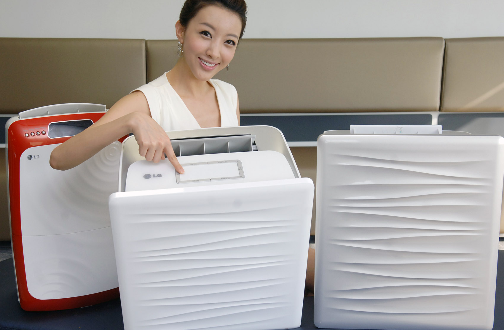 a woman smiling beside two air conditioners sitting on the floor