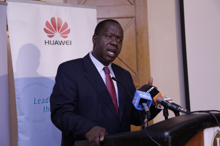 a man in a suit giving a speech in front of microphones