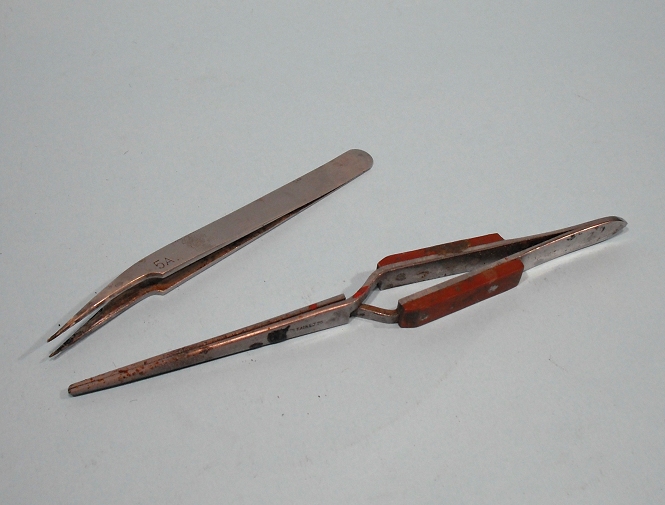 two pieces of copper with orange handles laying on the table