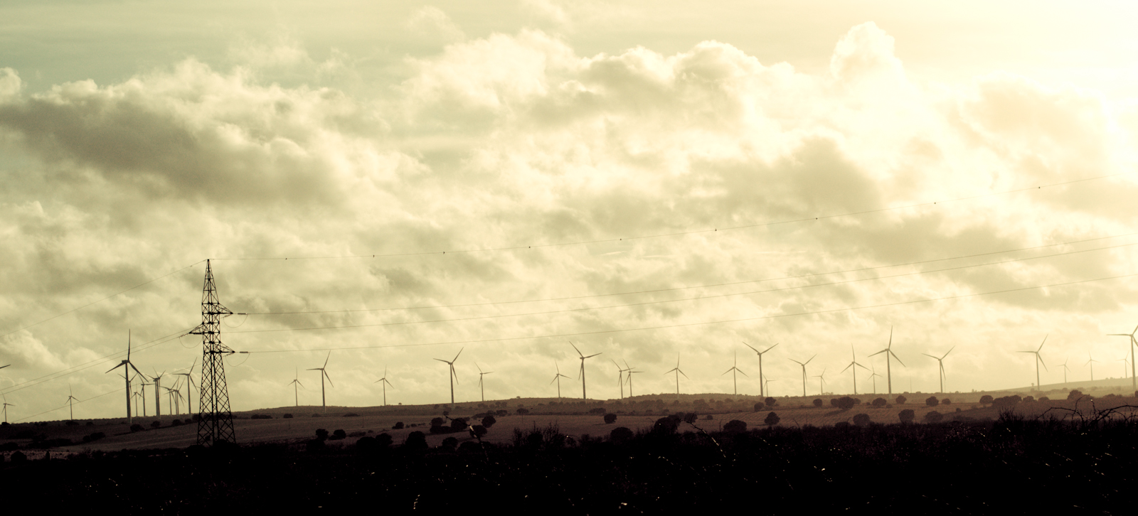 large industrial windmills on top of a hill