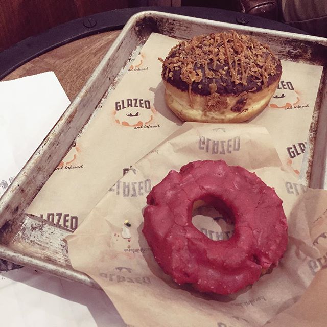 two doughnuts with pink icing are on display