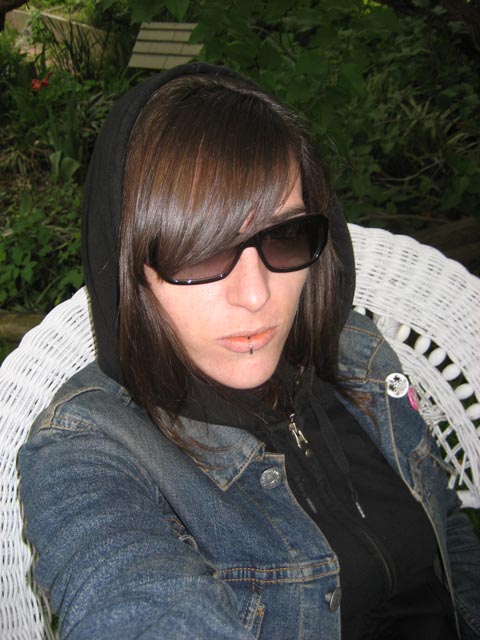 a woman in sunglasses sitting down with her hair wrapped up