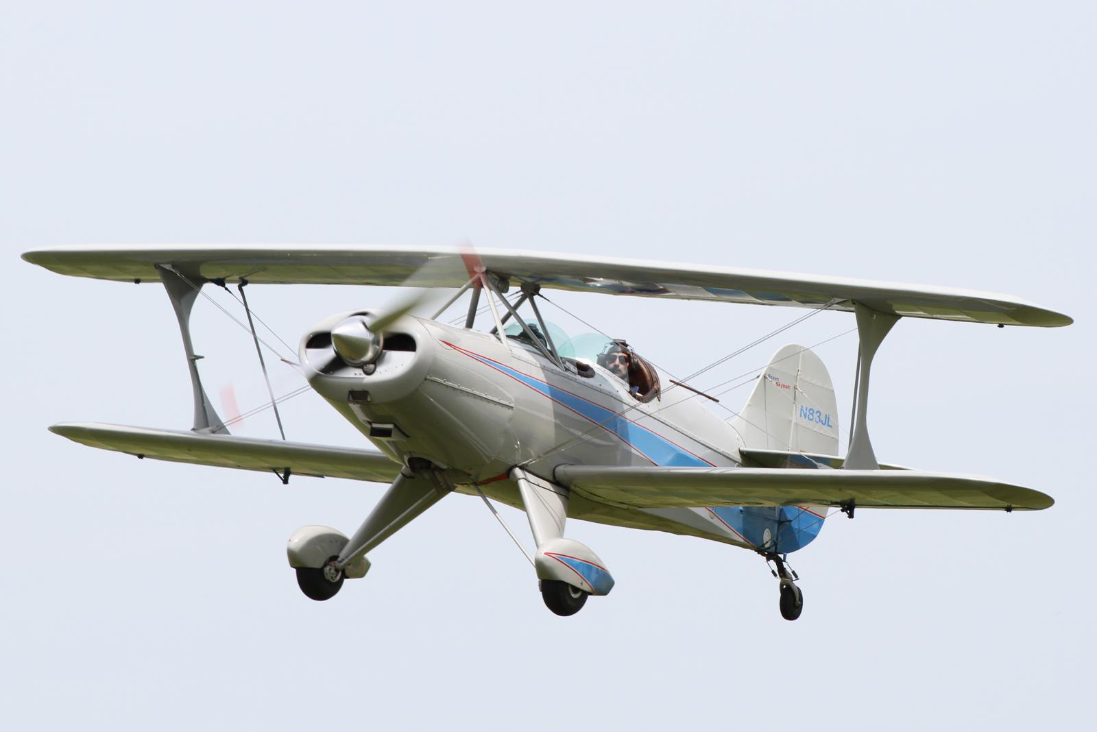 a small airplane flies through a cloudy sky