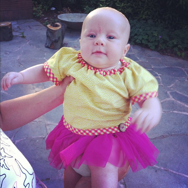 a baby in a tutu and yellow shirt